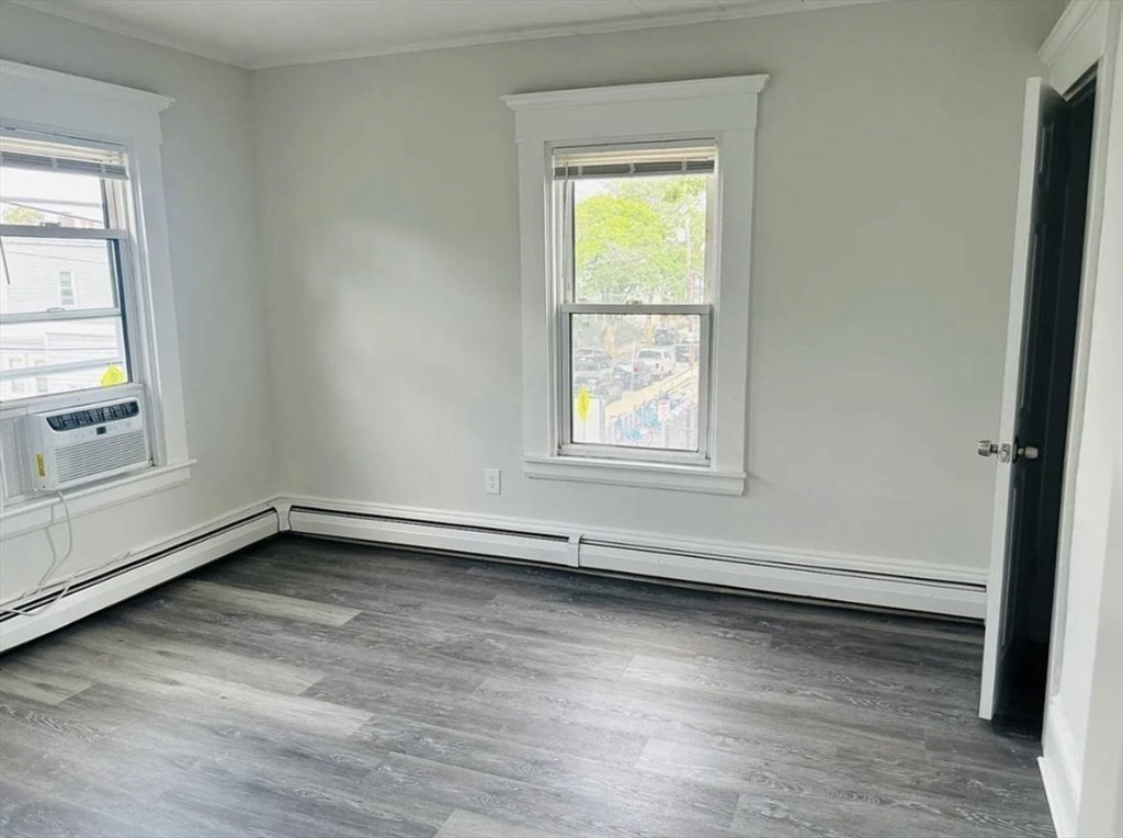 15 Ellsworth Street, Unit 2 Somerville, MA 02145 - Photo 13 of 16 an empty room with wooden floor and windows