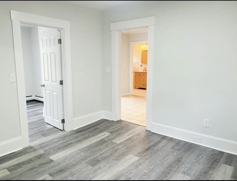 15 Ellsworth Street, Unit 2 Somerville, MA 02145 - Photo 8 of 16 an empty room with wooden floor and closet