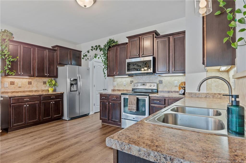 594 Allegiance Street Raeford, NC 28376 - Photo 11 of 49 a kitchen with stainless steel appliances granite countertop a refrigerator a stove top oven and a sink