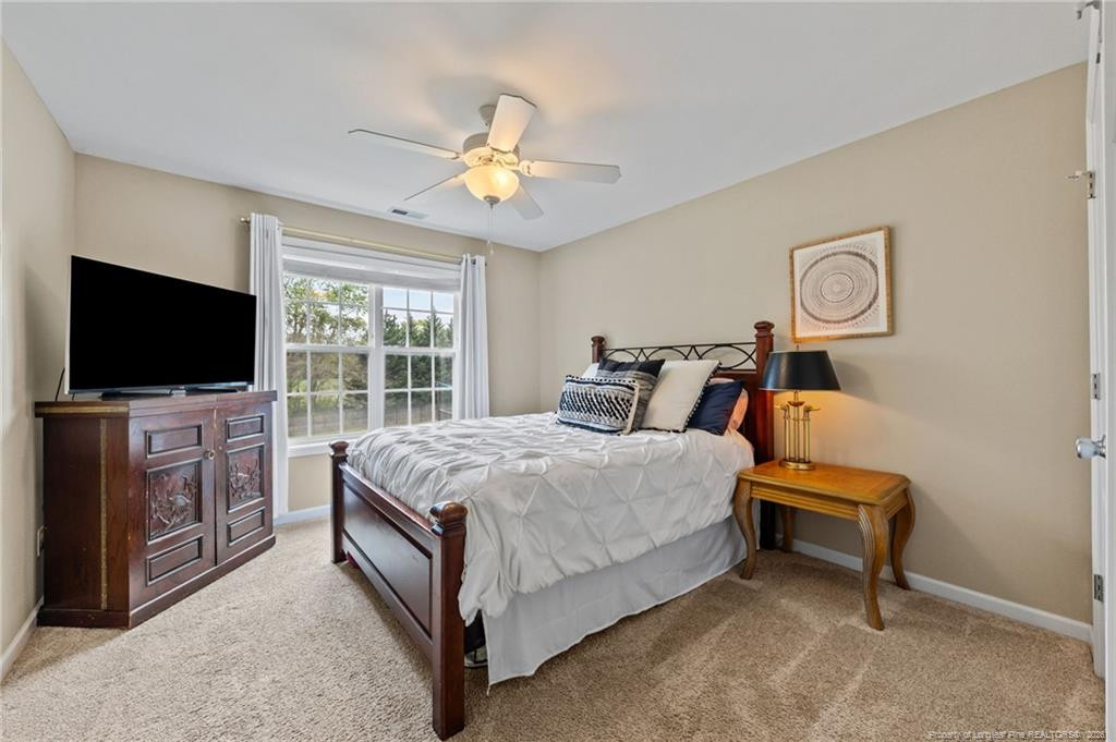 594 Allegiance Street Raeford, NC 28376 - Photo 18 of 49 a bedroom with a bed and a flat tv screen on dresser