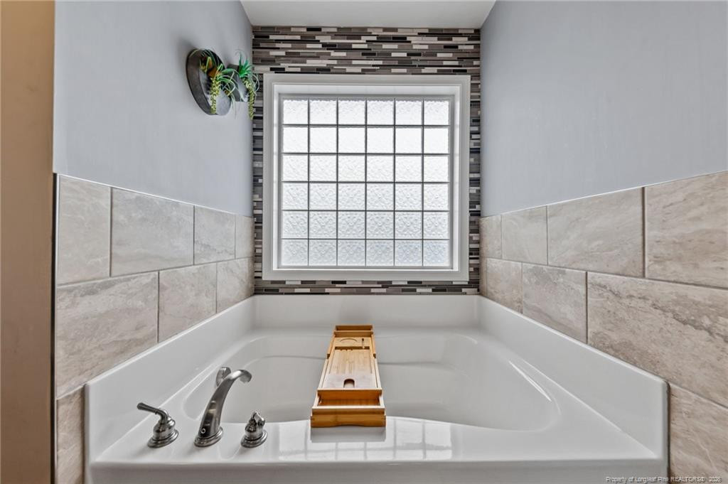 594 Allegiance Street Raeford, NC 28376 - Photo 29 of 49 a bathroom with a tub a window and a shower