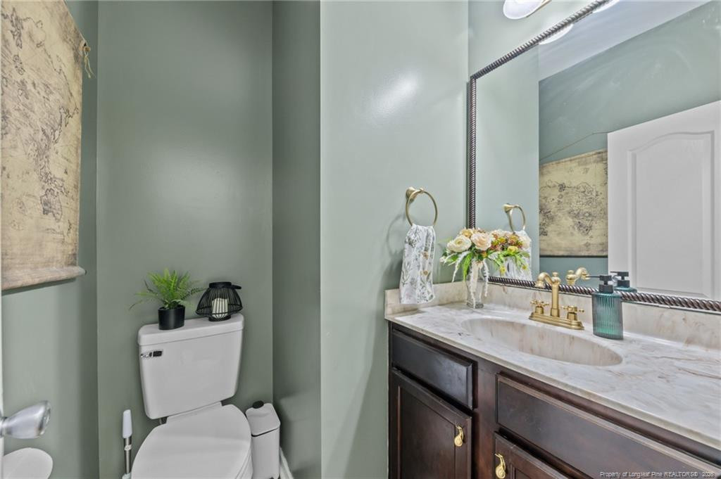 594 Allegiance Street Raeford, NC 28376 - Photo 7 of 49 a bathroom with a granite countertop sink a toilet and a mirror