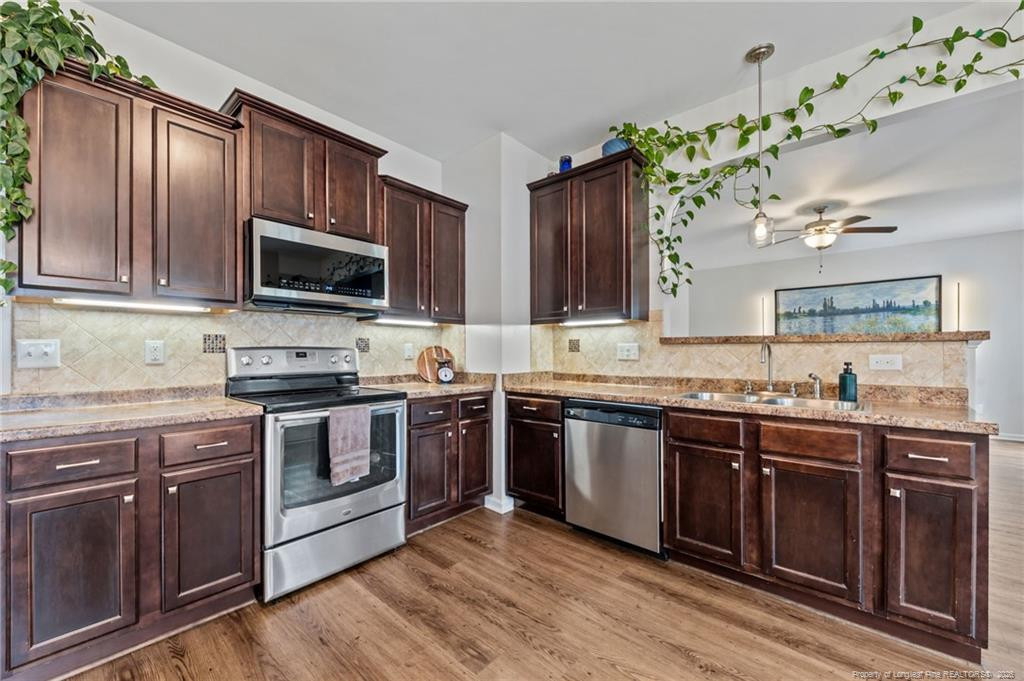 594 Allegiance Street Raeford, NC 28376 - Photo 10 of 49 a kitchen with granite countertop stainless steel appliances and wooden cabinets