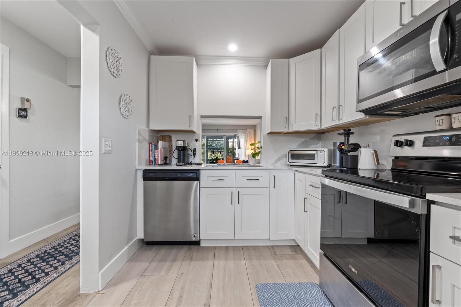 1501 South Ocean Boulevard, Unit 318 Lauderdale-by-the-Sea, FL 33062 - Photo 11 of 26 a kitchen with cabinets and wooden floor