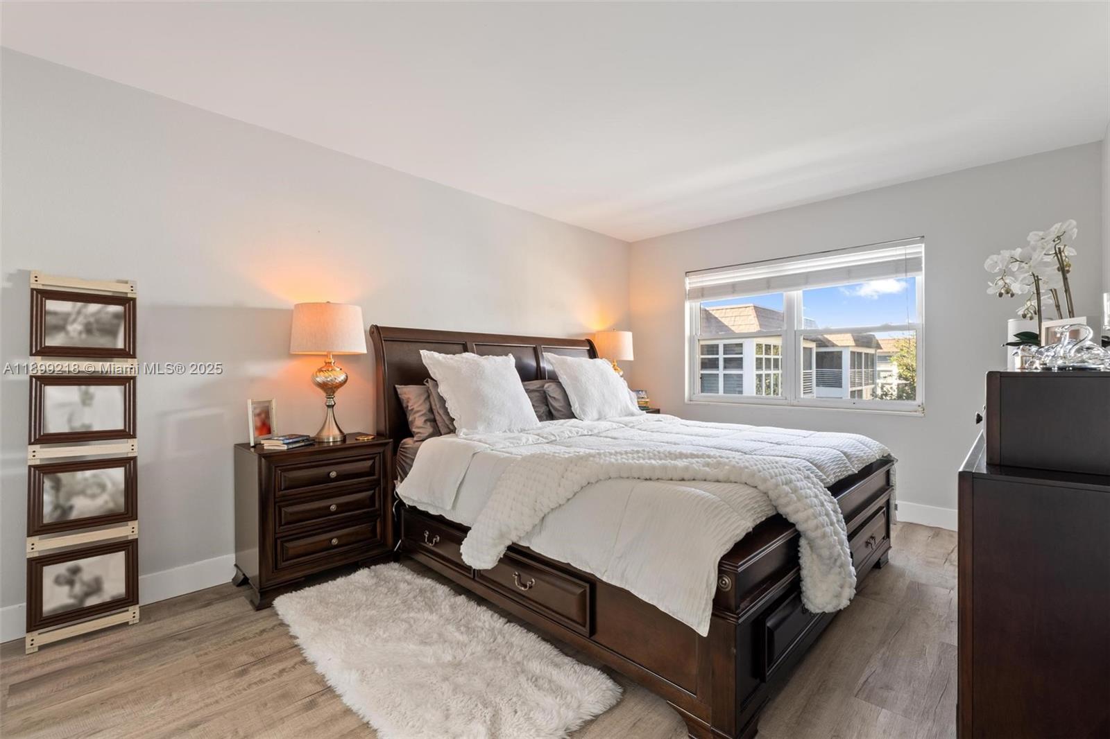 1501 South Ocean Boulevard, Unit 318 Lauderdale-by-the-Sea, FL 33062 - Photo 21 of 26 a bedroom with a bed window and a book shelf