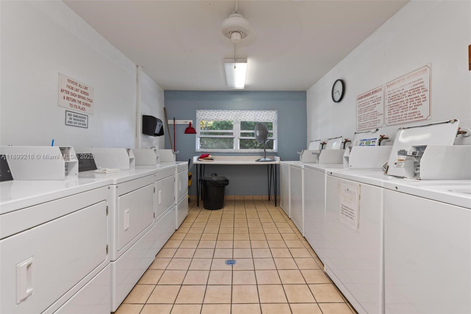 1501 South Ocean Boulevard, Unit 318 Lauderdale-by-the-Sea, FL 33062 - Photo 5 of 26 a large white kitchen with a sink a window and stainless steel appliances
