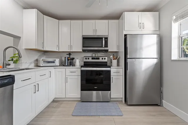 a kitchen with white cabinets and stainless steel appliances