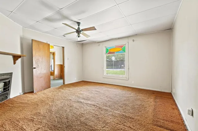 a view of empty room with a ceiling fan and window