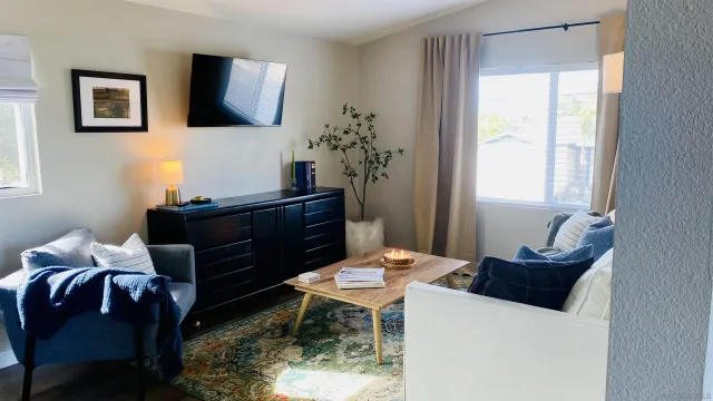 a living room with furniture a flat screen tv and a window