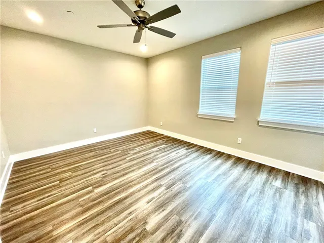 a view of a room with wooden floor and fan