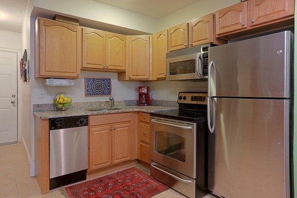 497 Beacon Street, Unit 9 Boston, MA 02215 - Photo 2 of 5 a kitchen with stainless steel appliances granite countertop a refrigerator sink and microwave