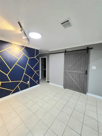 a room with white cabinets and wooden floor