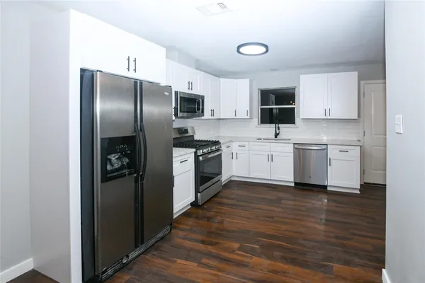 a kitchen with stainless steel appliances a refrigerator sink and microwave