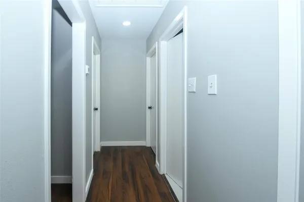 a view of a hallway with wooden floor
