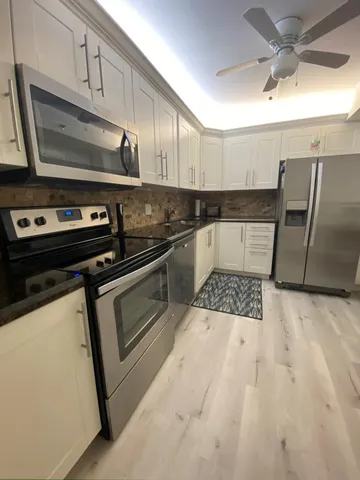 a kitchen with stainless steel appliances a stove a microwave and sink