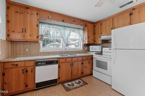 a kitchen with granite countertop a sink stainless steel appliances and window