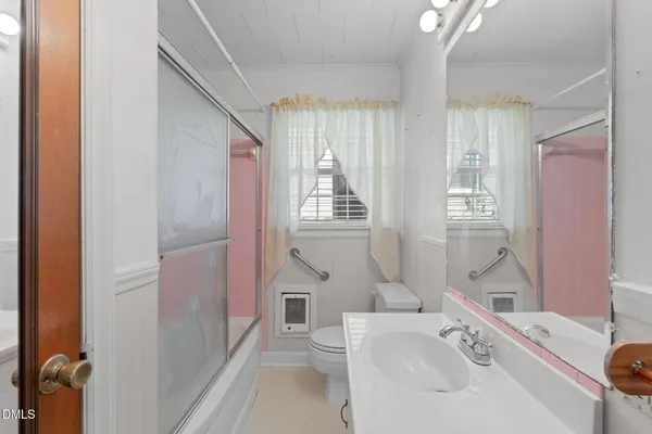 a bathroom with a sink a toilet a tub and shower