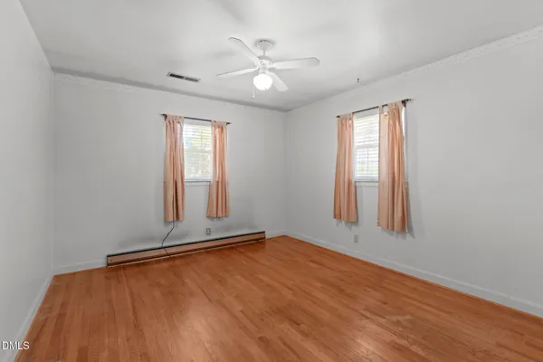 an empty room with a window and ceiling fan