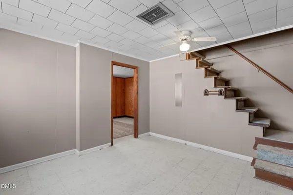 an empty room with stairs and windows
