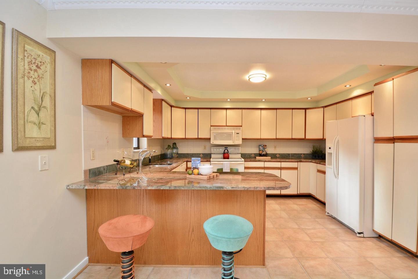 8421 Alvin Road Pasadena, MD 21122 - Photo 11 of 26 a kitchen with stainless steel appliances granite countertop a sink dishwasher a stove a refrigerator with a dining table and chairs