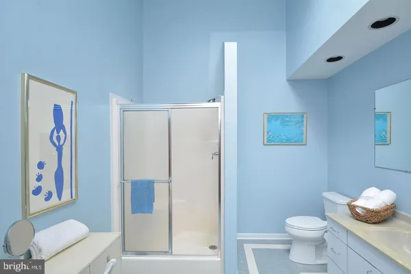 a bathroom with a granite countertop sink toilet and shower