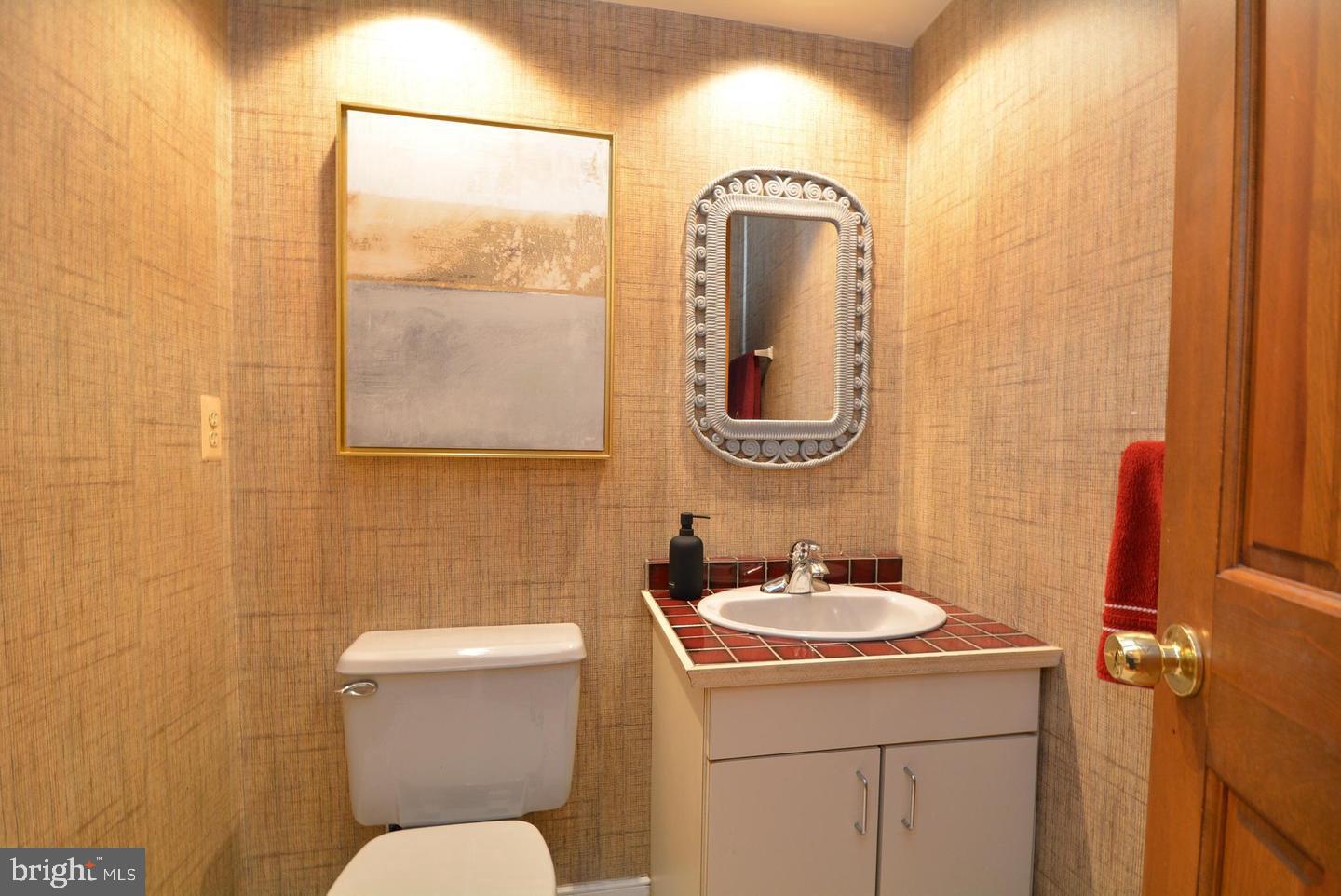 8421 Alvin Road Pasadena, MD 21122 - Photo 37 of 54 a bathroom with a sink mirror vanity and toilet