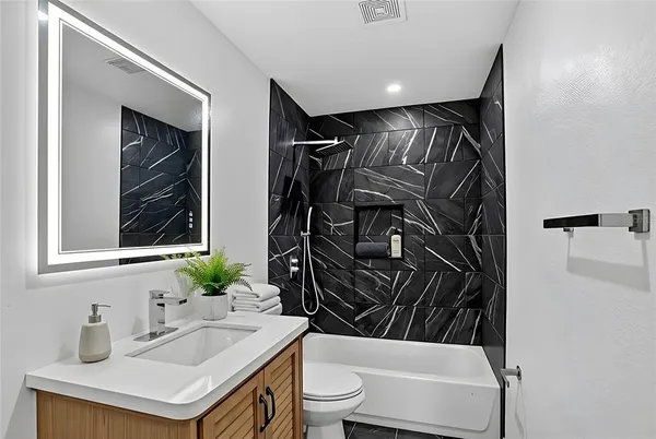 a bathroom with a sink a toilet and shower