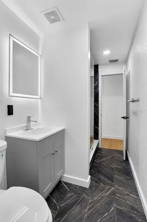 a bathroom with a sink mirror vanity and toilet