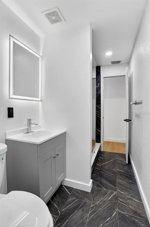 101 West Celeste Street Apopka, FL 32703 - Photo 24 of 47 a bathroom with a sink mirror vanity and toilet