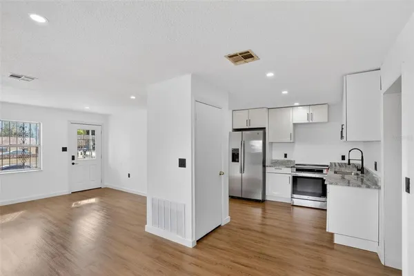 a kitchen with stainless steel appliances granite countertop a refrigerator and a stove top oven