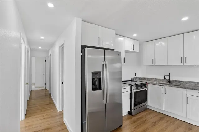 a kitchen with stainless steel appliances a refrigerator sink and cabinets