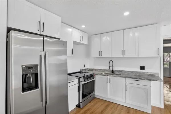 a kitchen with a refrigerator sink and cabinets