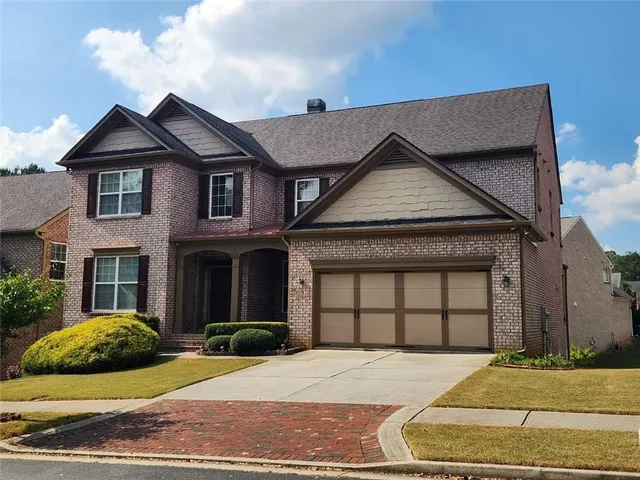 a front view of a house with a garden