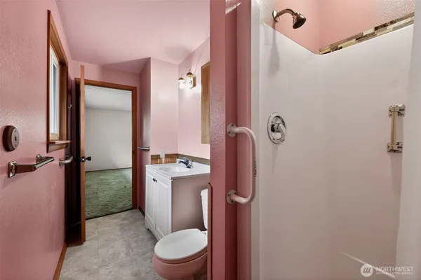a bathroom with a granite countertop toilet a sink and shower