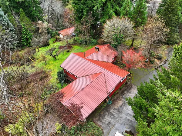 an aerial view of a house with a yard and trees