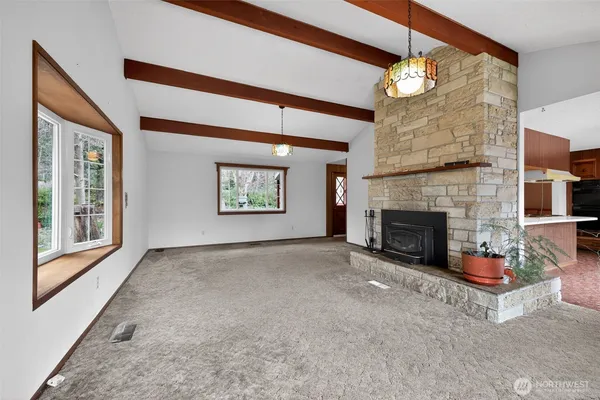 a view of an empty room with a fireplace and a window