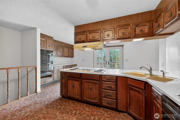 a kitchen with stainless steel appliances granite countertop a sink stove and cabinets