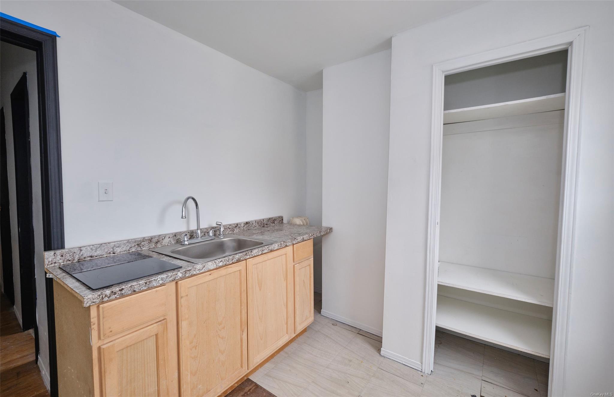 80-19 86th Road Queens, NY 11421 - Photo 12 of 26 a kitchen with a granite countertop sink and white cabinets