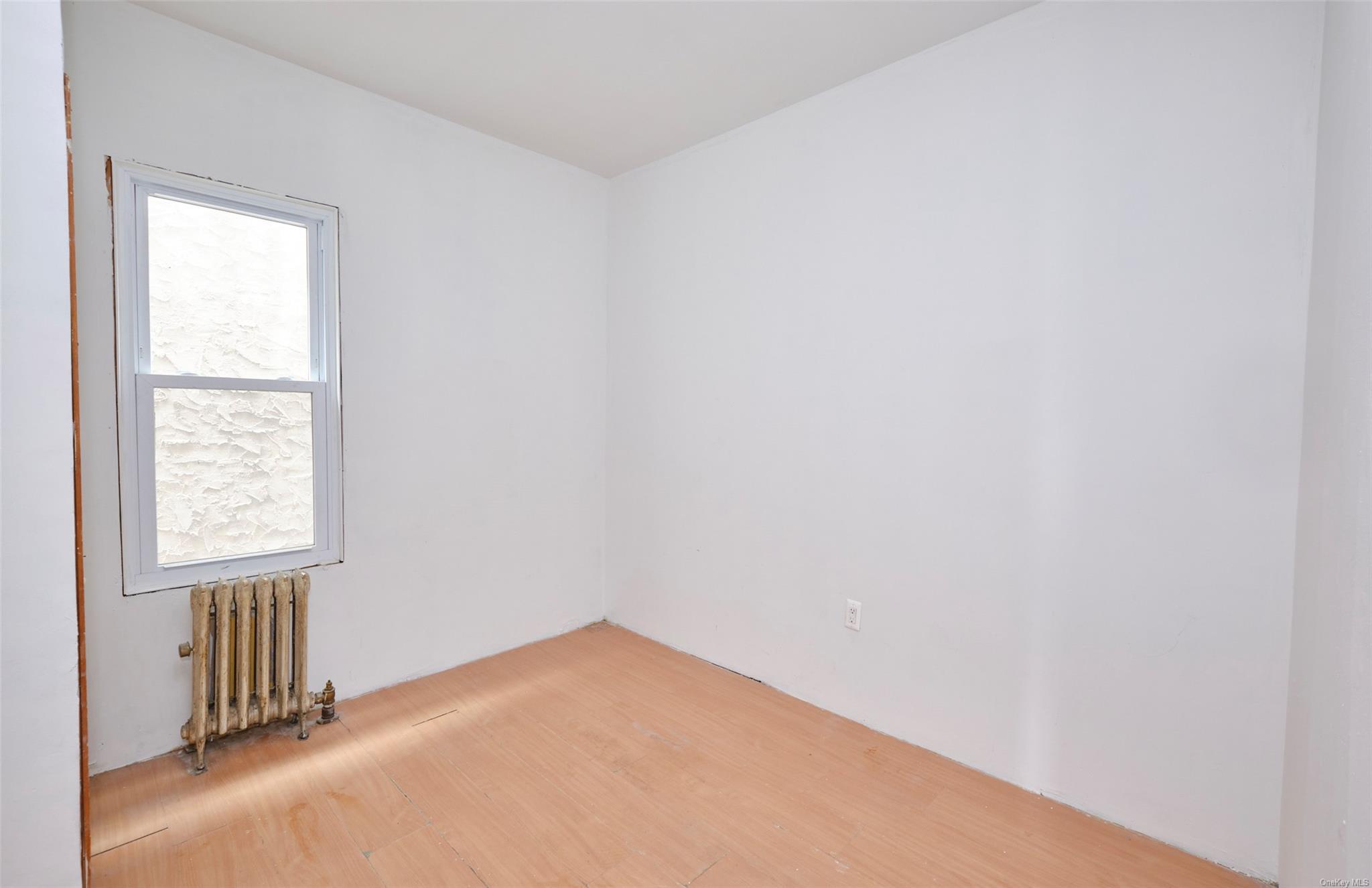 80-19 86th Road Queens, NY 11421 - Photo 13 of 26 an empty room with a window
