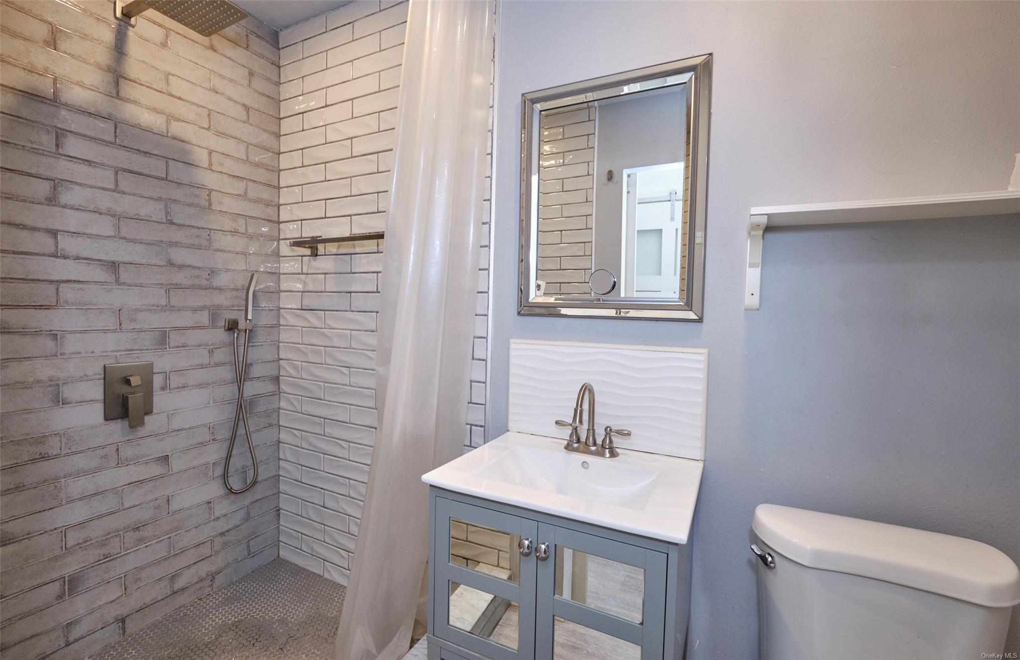 80-19 86th Road Queens, NY 11421 - Photo 6 of 26 a bathroom with a sink a toilet and mirror