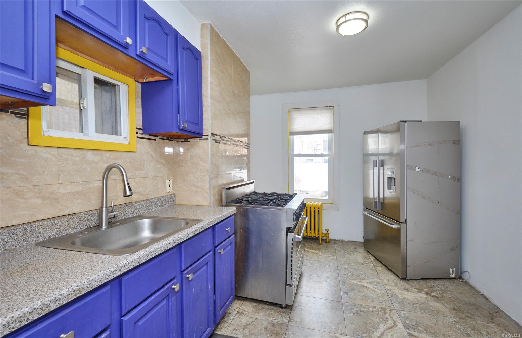 80-19 86th Road Queens, NY 11421 - Photo 7 of 26 a kitchen with a sink cabinets and stainless steel appliances