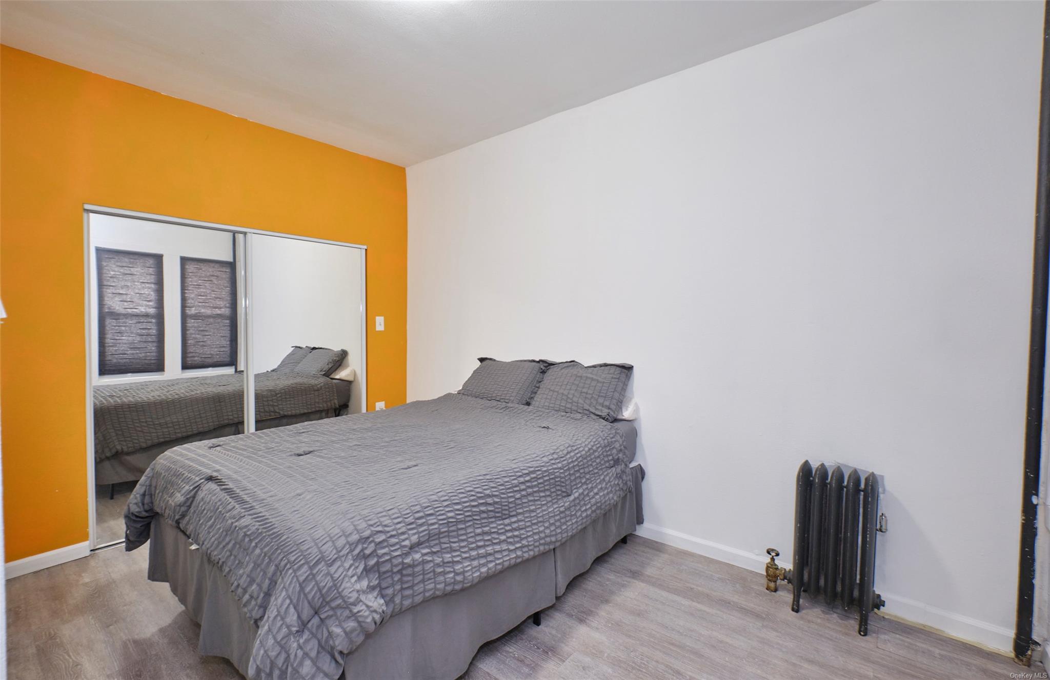 80-19 86th Road Queens, NY 11421 - Photo 9 of 26 a bedroom with a bed and a large window