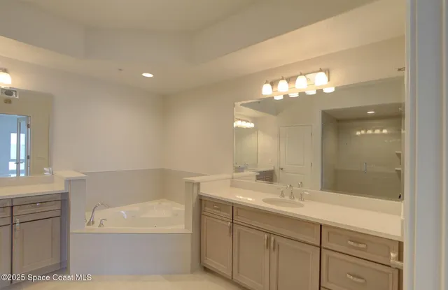 a spacious bathroom with a double vanity sink a large mirror and shower
