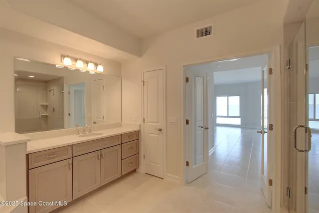 a bathroom with a bathtub a sink a vanity a lamp and a mirror