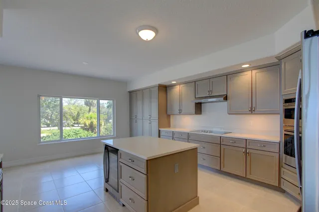 a kitchen with stainless steel appliances granite countertop a refrigerator and a stove top oven