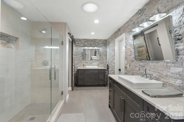 a bathroom with a granite countertop sink mirror and shower