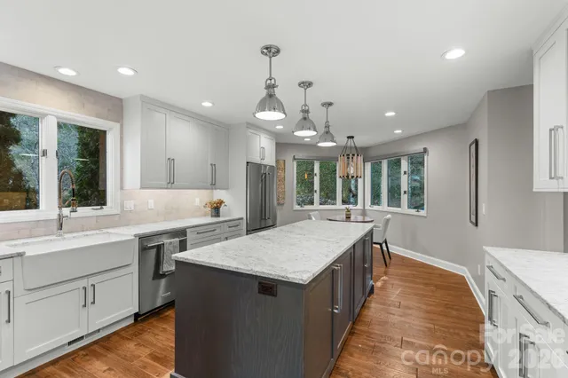 a large kitchen with kitchen island a sink stainless steel appliances and cabinets