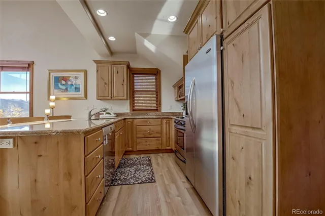 a kitchen with granite countertop a refrigerator and a sink