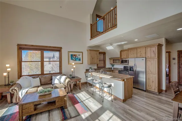 a living room with furniture a refrigerator and kitchen view