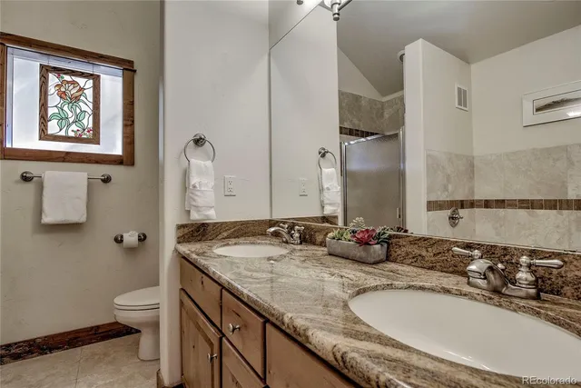 a bathroom with a granite countertop sink a toilet and a mirror